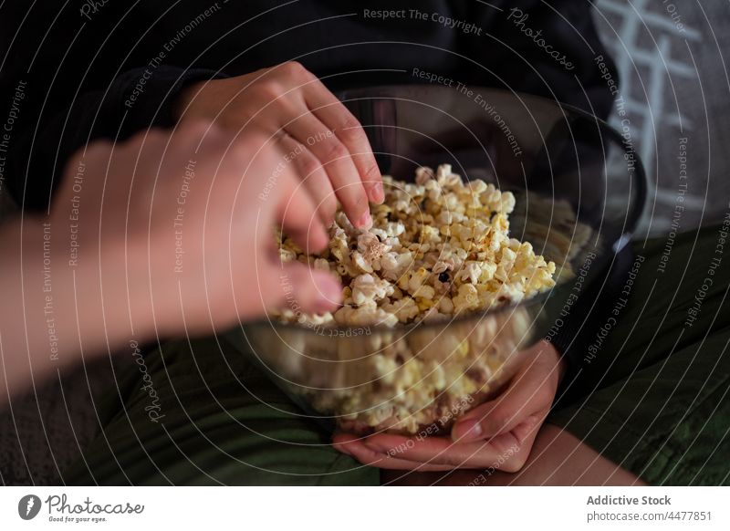 Anonymes Paar sitzt auf dem Sofa und isst Popcorn essen Popkorn Liege sitzen zu Hause sich[Akk] entspannen genießen Freizeit Appartement Wohnzimmer heimwärts