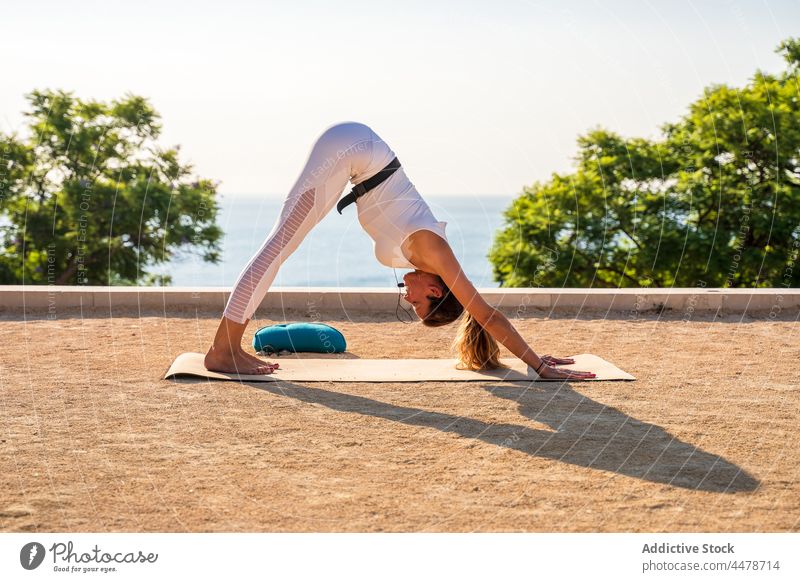 Dame bei Adho Mukha Shvanasana Frau nach unten gerichteter Hund adho mukha shvanasana Yoga Übung positionieren üben Pose beweglich Wellness Unterlage Barfuß