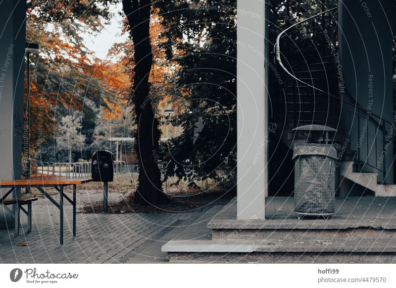 Mülleimer auf Treppe mit Wendeltreppe, Bierzeltgarnitur und herbstlicher Laubfärbung Papierkorb abfallbehälter hebstlich Herbstlaub Tristesse trist melancholie