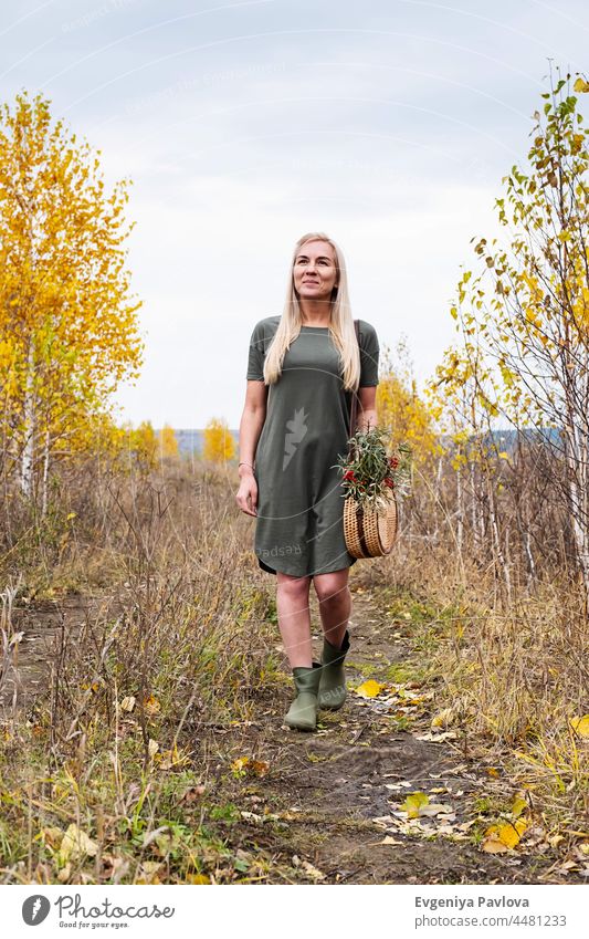 Schöne blondie Frau mit trendigen Rattan gewebt Runde Schulter Handtasche, draußen. Scenic Natur, Herbst-Saison. Mode Feld handgefertigt Dame Landschaft