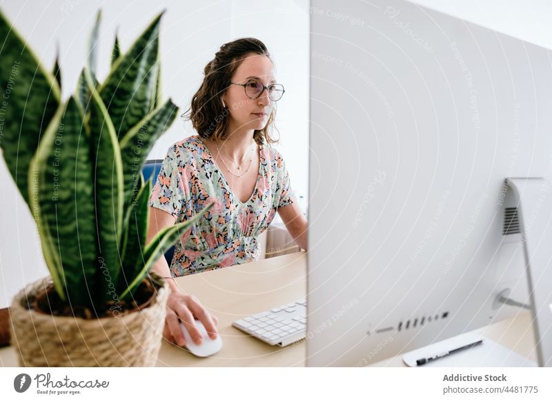 Frau mit Mobiltelefon im Büro benutzend Browsen Computer Lächeln Brille Telefon Surfen Talkrunde Internet Anschluss Schreibtisch Apparatur Mobile online Job