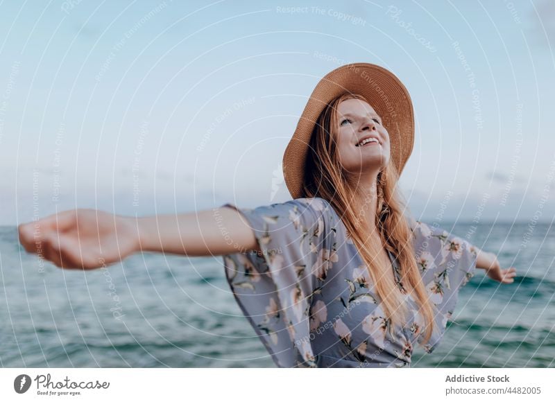 Glückliche Frau am Sandstrand stehend MEER Strand Lächeln Wasser Kleid Sommer Abend jung Natur Küste Ufer Hand Person Meeresufer Harmonie Meeresküste Himmel