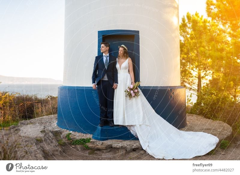 Ein Ehepaar an der Tür eines Leuchtturms Hochzeit Ehemann Ehefrau Bekleidung Liebe Feier Textfreiraum Paar heterosexuell Braut striegeln Wald Baum