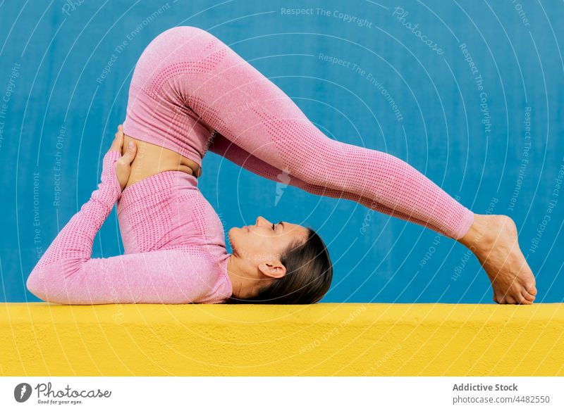 Frau in Activewear bei Übungen Unterlage Training Sportbekleidung üben farbenfroh Aktivität Dehnung beweglich schlank passen Wellness Wand hell Fitness