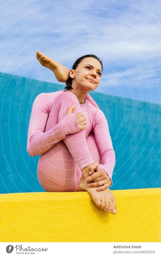 Verträumte junge Frau meditiert in der sitzenden Wiege-Pose Yoga Asana Wellness Achtsamkeit üben meditieren Gleichgewicht Zen Windstille Gesundheit Harmonie