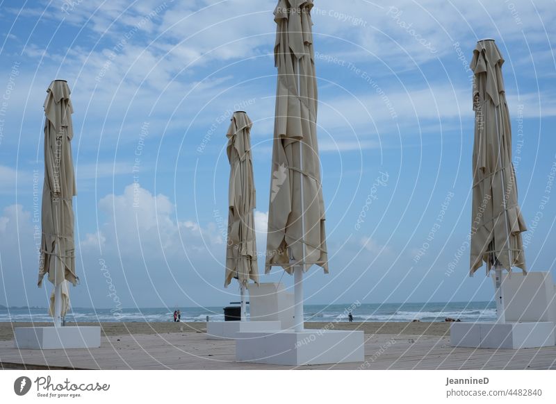 vier geschlossene Sonnenschirme am Strand Saisonende Menschenleer Tourismus Venedig Ferien & Urlaub & Reisen Meer Himmel Wolken Horizont schauen Weitblick Ende