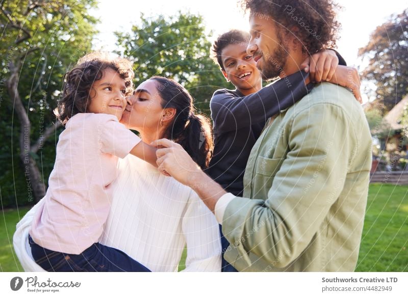 Porträt einer Familie im Garten, Mutter küsst Sohn gemischte Rasse asiatisch Kuss Vater Liebe im Freien Tag vier Menschen authentisch Kindheit Lifestyle Glück