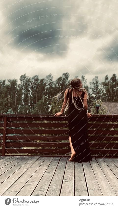 Mädchen mit Dreadlocks vor dem Sturm Frau Rastalocken Wein Weinglas schwarzer Himmel Unwetter Gewitterwolken stürmisch Gewitterhimmel stürmische Atmosphäre Wind