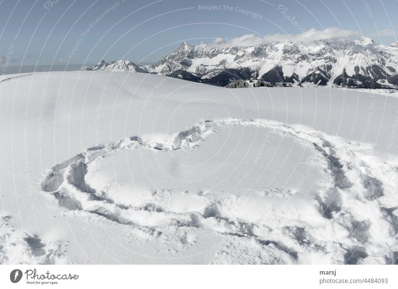 Liebesbezeugung im Winter, in den Schnee getreten. Bergwelt im Hintergrund Verliebtheit Romantik romantisch Herz herzförmig Spuren im Schnee Skitour