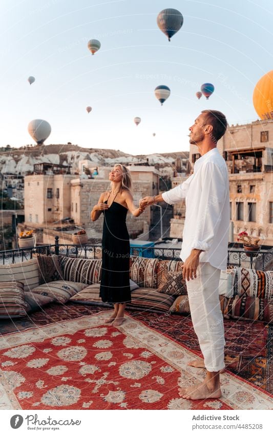 Paar tanzt gegen fliegende Heißluftballons Tanzen Seelenverwandter Ballone Dachterrasse Termin & Datum romantisch Zusammensein Liebe Partnerschaft Bonden