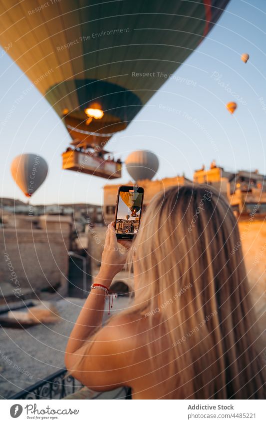 Frau fotografiert Heißluftballons Ballone Funktelefon Smartphone fotografieren schießen Telefon Apparatur benutzend Blogger Gedächtnis Zaun Mobile Foto Moment