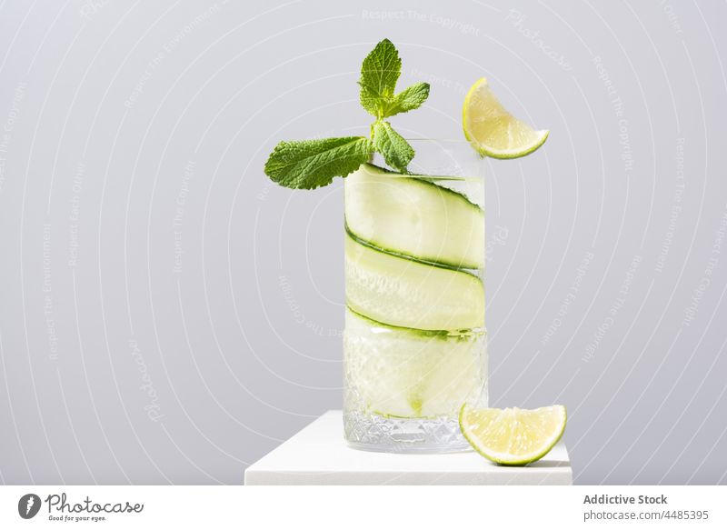 Erfrischender Cocktail mit Limette und Gurke, serviert auf einem weißen Tisch Gin Tonic Kalk Salatgurke Zitrusfrüchte Alkohol Minze Getränk Frucht cool