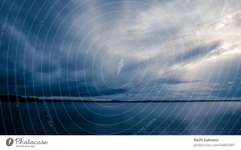 Wolkenlandschaft oder Wasserlandschaft. Ruhige wellenlose See Spiegeloberfläche reflektiert schöne Wolken in Abend Sommer Sonnenuntergang Licht Hintergrund