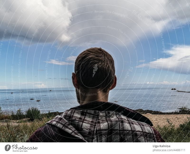 Rückansicht eines jungen Mannes mit Blick auf das Meer Ein Mann allein 1 Mensch Wasseroberfläche Ein junger erwachsener Mann einzeln Jugendliche Erwachsene