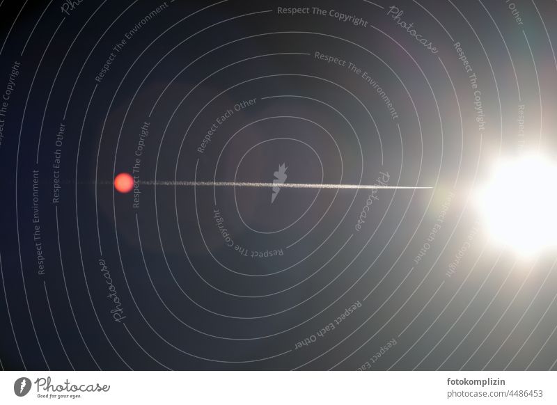 Kondensstreifen eines Flugzeugs, welches scheinbar in die Sonne fliegt Flugzeugspur Luftverkehr Streifen fliegen surreal Himmel Freiheit Geschwindigkeit Ferne