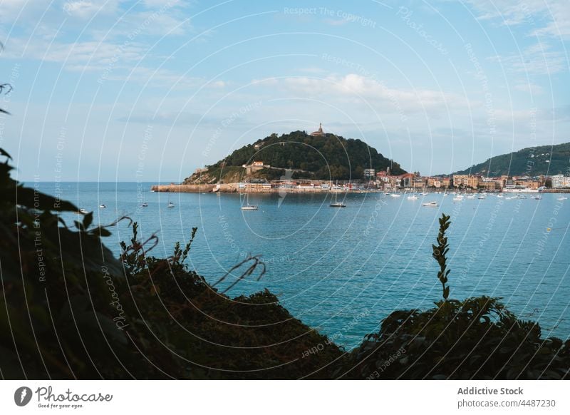 Boote schwimmen im Meer in der Nähe von Küstenstadt in sonnigen Tag Großstadt Wasser Schwimmer Segelboot Umwelt Hügel Stadtbild Gefäße donostia San Sebastián