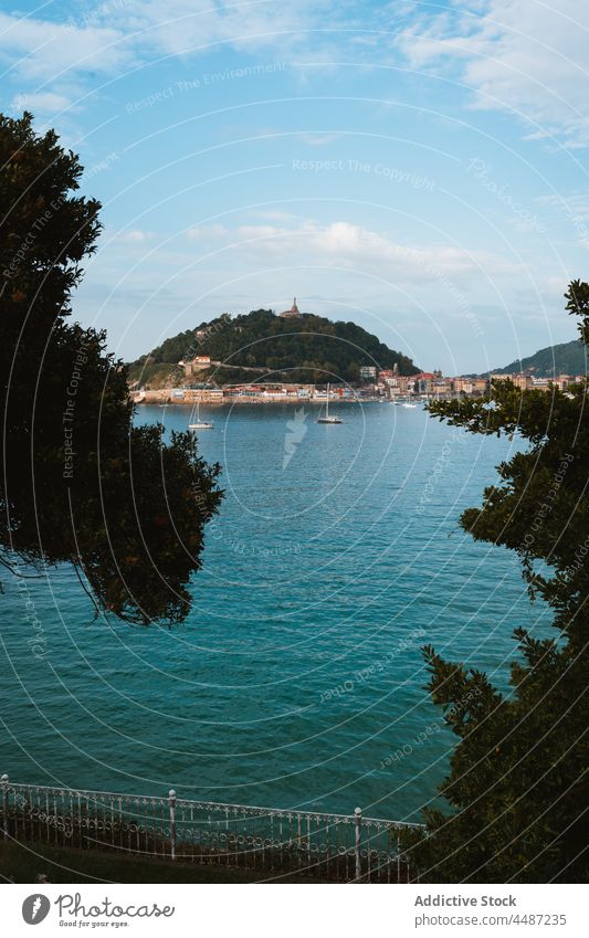 Boote schwimmen im Meer in der Nähe von Küstenstadt in sonnigen Tag Großstadt Wasser Schwimmer Segelboot Umwelt Hügel Stadtbild Gefäße donostia San Sebastián