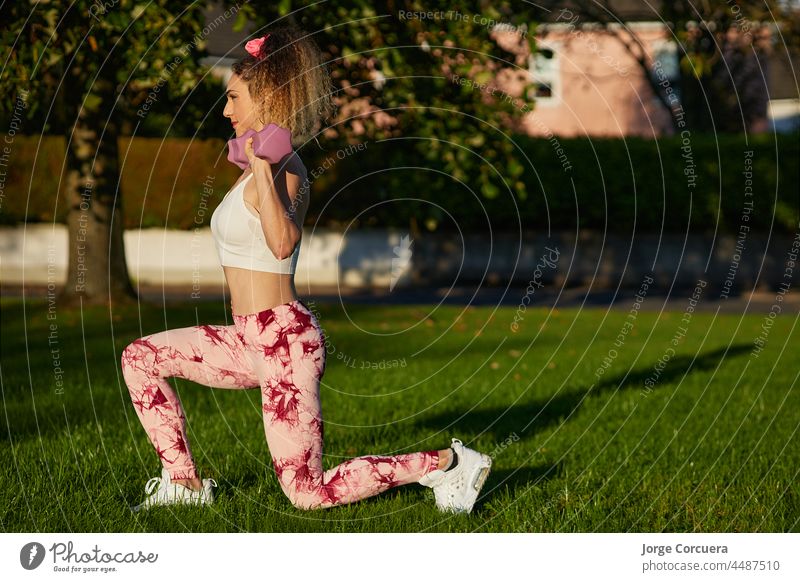 Frau in den 20ern hebt Hantelgewichte in Sportkleidung. Sport, Fitness Konzept 20s Gewicht Heben Sportbekleidung Kurzhantel passen stark jung Kaukasier Arme