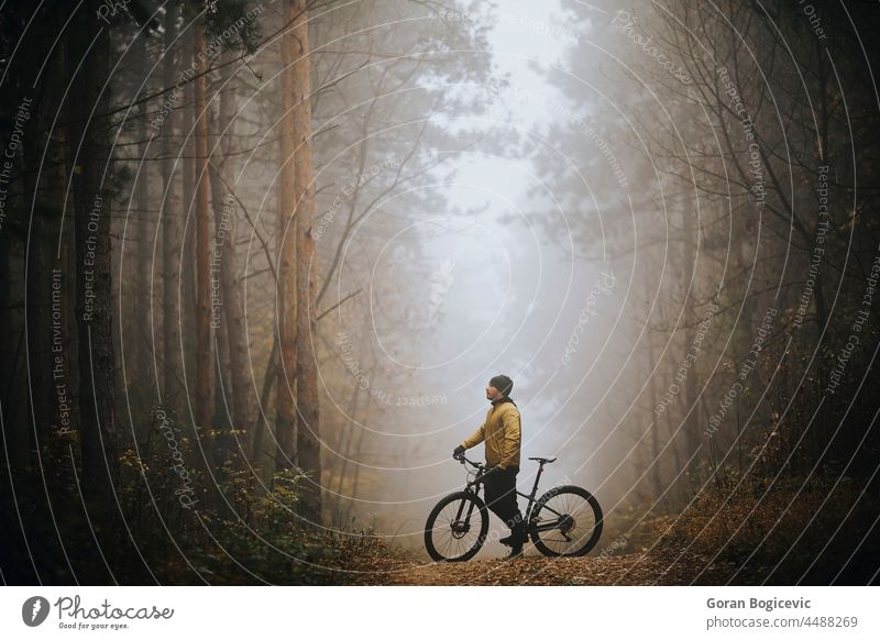 Junger Mann macht eine Pause beim Radfahren durch den Herbstwald Aktion aktiv Aktivität Abenteuer Athlet Fahrrad Radfahrer Biker Zyklus Übung extrem schnell