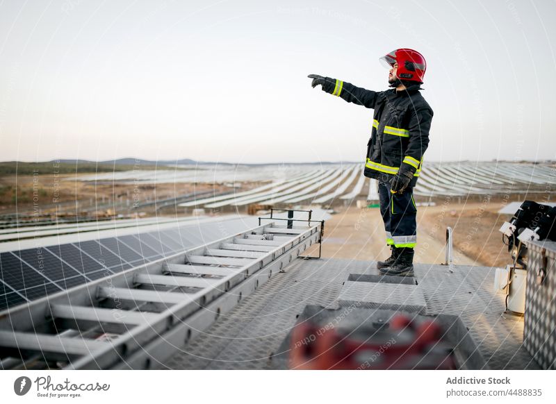 Feuerwehrmann steht auf dem Dach eines Lastwagens Mann Uniform Gerät professionell Bauernhof Sonnenkollektor Beruf Schutzhelm stehen männlich Motor Mut