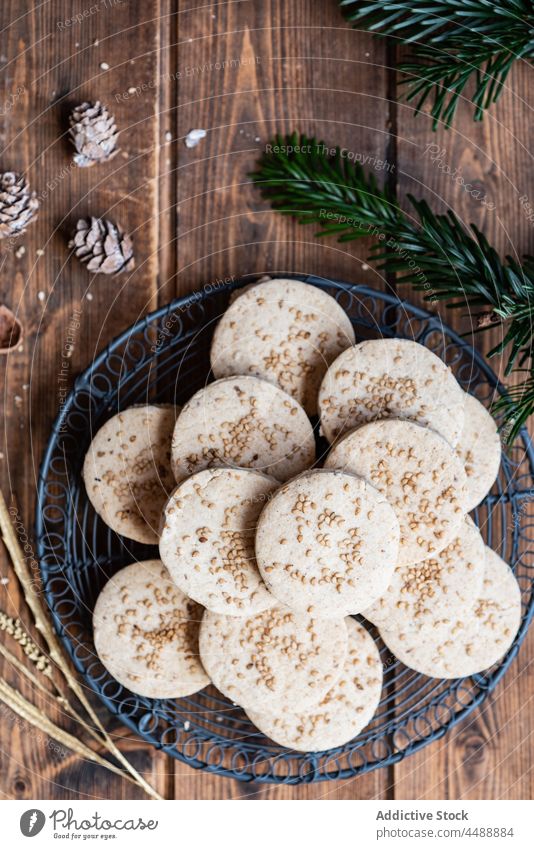 Stapel von Butterkeksen mit Nüssen im Teller Keks Weihnachten polvoron Feiertag süß Dessert Haselnuss Tisch hölzern geschmackvoll lecker Snack Ast Zapfen