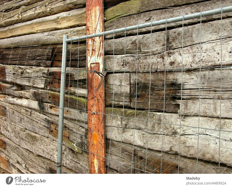 Drahtgitter vor einem alten hohen Holzzaun mit rostigem Pfeiler am ehemaligen Binnenhafen von Offenbach am Main in Hessen Wand Holzwand Zaun Absperrung