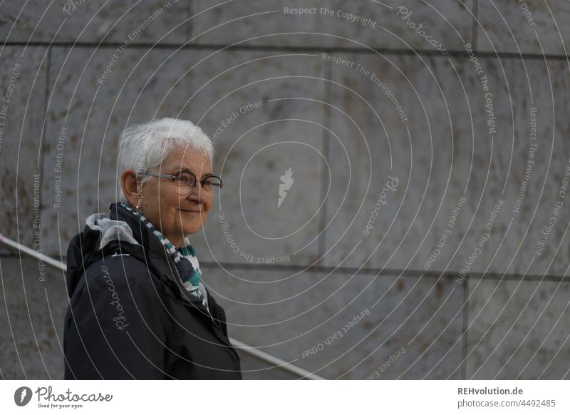 Seniorin in urbanem Umfeld Portrait Rentnerin alt Brille weißhaarig Erwachsene 60 und älter Weiblicher Senior Tag Freundlichkeit Mensch Beton Frau Porträt