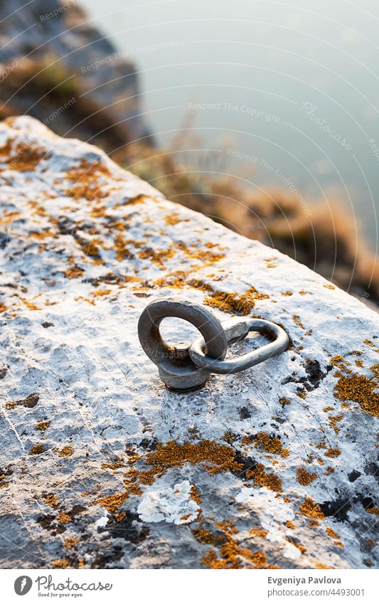 Сlimbing Karabinerhaken und Auslöser Gerät in Stein. Karabiner für Bergsteigen auf felsigen und Meereslandschaft Hintergrund. Extreme Sport Konzept. Klettern