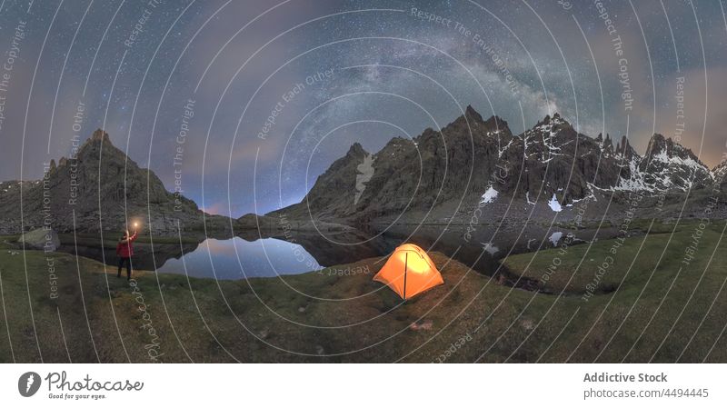 Reisender mit Licht in der Hand steht in der Nähe von Zelt in den Bergen in sternenklarer Nacht Zeit Berge u. Gebirge Natur reisen Circo de Gredos Abenteuer