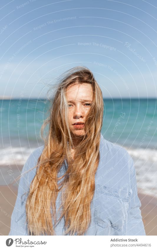 Ruhige Frau am Sandstrand stehend MEER Strand Sommer Wasser Meeresufer Windstille Natur Umwelt Ufer Küste winken jung trendy Seeküste tagsüber friedlich