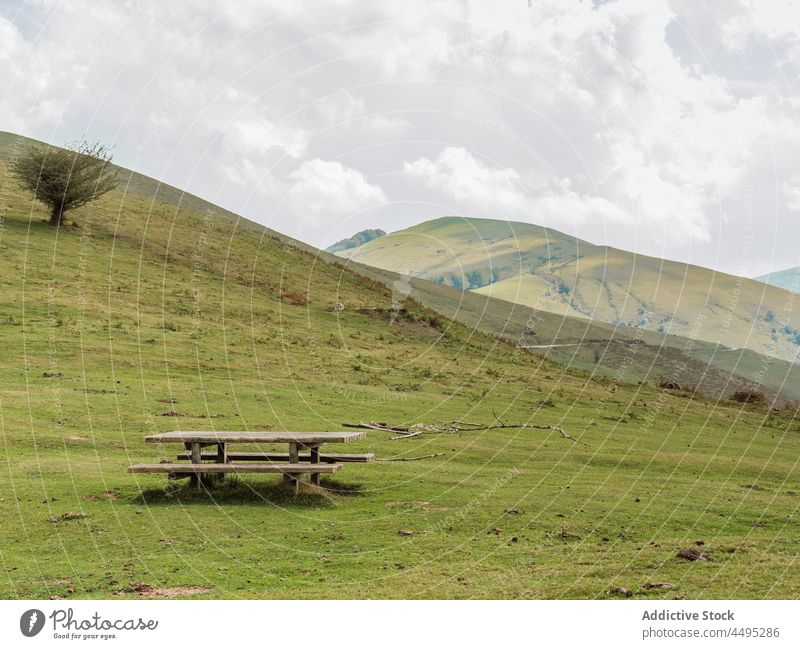 Hügeliges Terrain mit Holztisch Landschaft rustikal Tisch Natur Feld Umwelt Hügelseite Bank malerisch grün Sommer natürlich Grün pflanzlich Szene Gelände