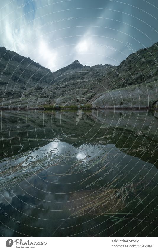 Ruhiger See, umgeben von Bergen Wasser Natur Berge u. Gebirge Küste Felsen Wasserseite Stein Seeufer Klippe Umwelt malerisch Ufer aqua fließen Formation