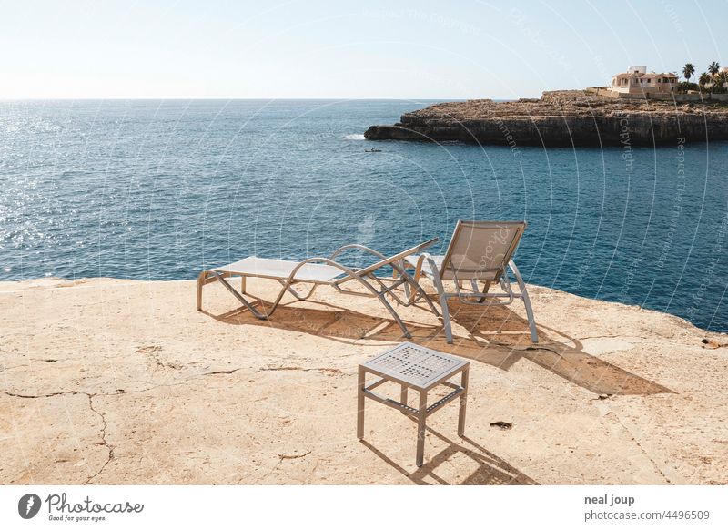 Sonnenliegen am Rand einer Klippe im Morgenlicht mit Blick auf den Horizont des Meeres Urlaub Reisen Tourismus Sommerurlaub Wärme Ruhe Ferien & Urlaub & Reisen