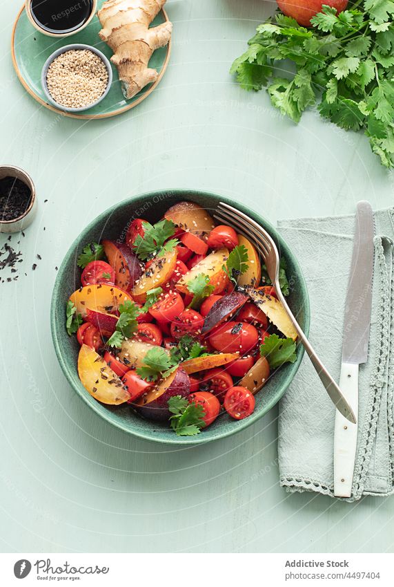 Tomatensalat mit Obst auf dem Tisch Salatbeilage Teller Vegetarier farbenfroh Zutaten Frucht Pflaume balsamisch Sommergerichte Mahlzeit Mittagessen Speise