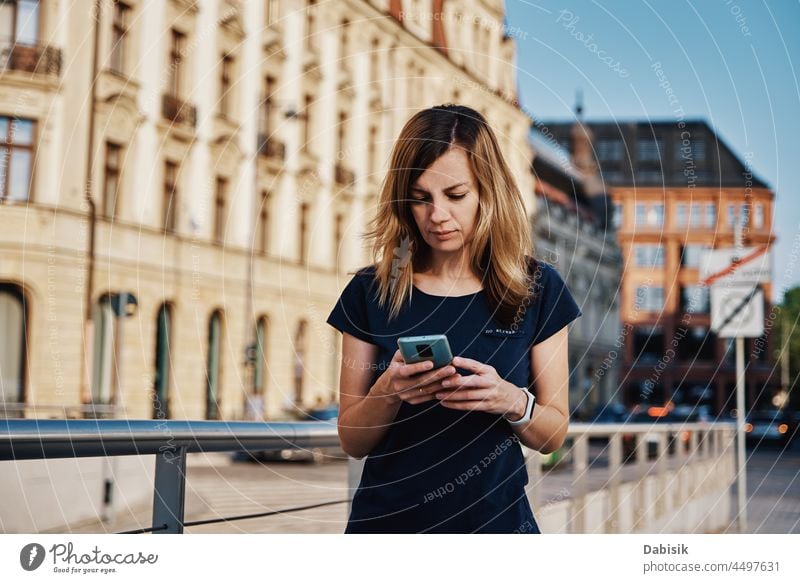 Frau benutzt Smartphone auf einer Straße in der Stadt Mobile laufen Lifestyle Kommunizieren online Porträt Telefon benutzend Fröhlichkeit tragbar Information