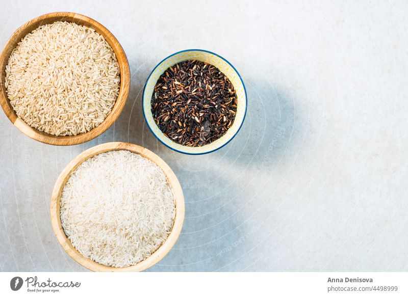 Verschiedene Reissorten in Holzschalen wie Basmati, brauner Reis und anders Schalen & Schüsseln weiß Tisch verschiedene hölzern Zerealien schwarz Thai