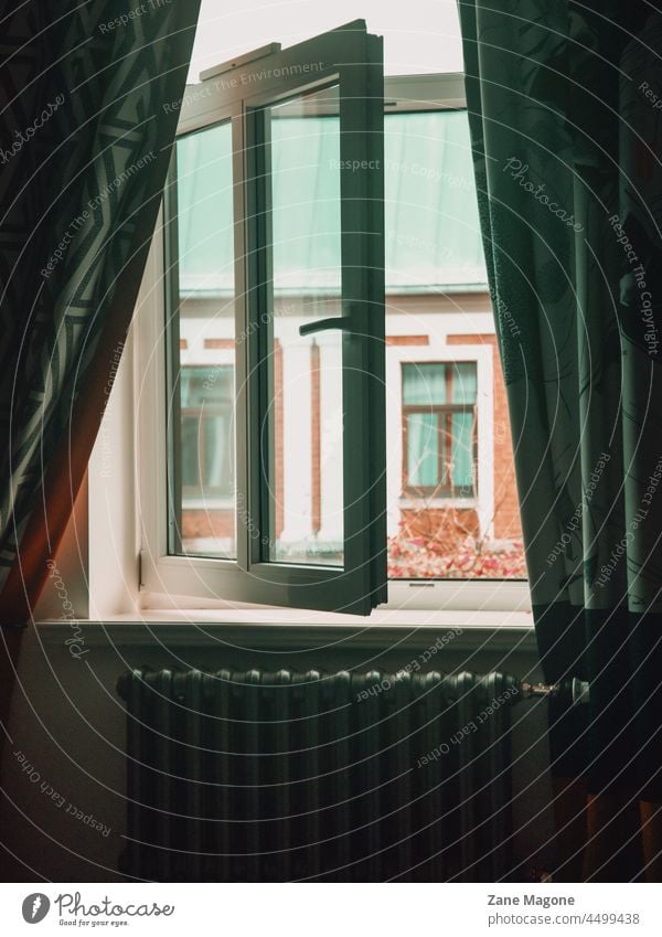 Vintage-Heizkörper und offenes Fenster mit Blick nach draußen, stimmungsvolle Herbstszene Heizung Zentralheizung Herbststimmung Blick durch das Fenster Vorhänge