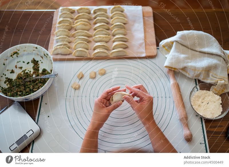 Gesichtslose Köchin beim Füllen von Teig mit Fleisch Frau Zeug Knödel Teigwaren jiaozi Asiatische Küche Koch Tradition selbstgemacht Lebensmittel Schürze Mehl