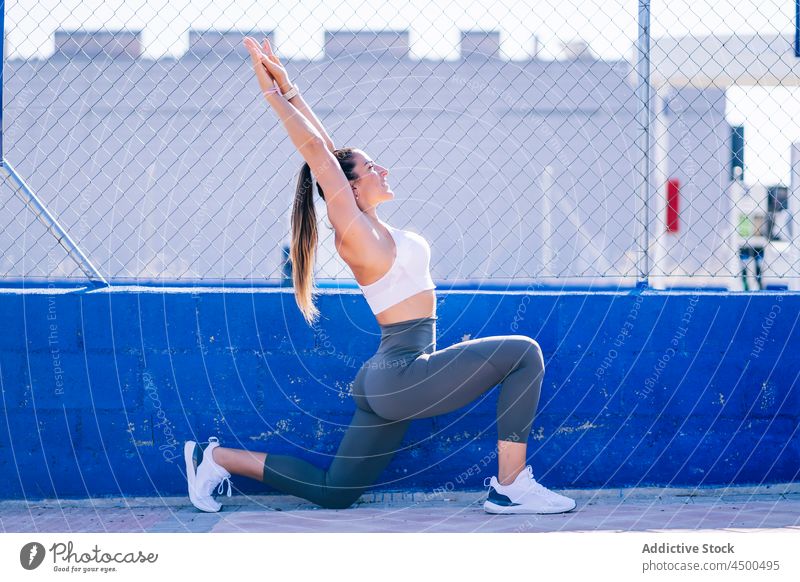 Fitte Frau macht Ausfallschritte auf dem Sportplatz Übung passen Fitness Training sportlich schlank Sportbekleidung Sportpark Sportkleidung Lifestyle Wellness