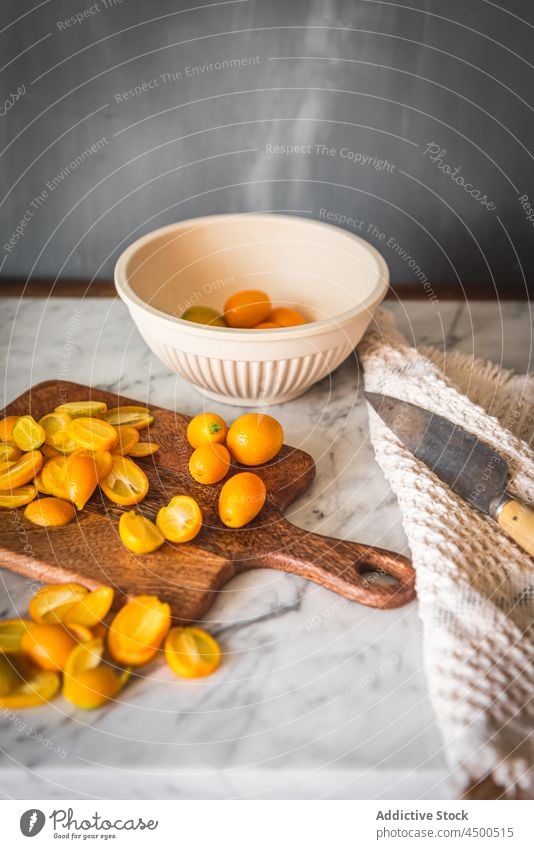 Haufen Kumquats auf Schneidebrett Frucht organisch natürlich gesunde Ernährung Zitrusfrüchte geschnitten Vitamin Küche frisch reif hölzern Gesundheit Murmel