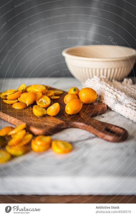 Haufen Kumquats auf Schneidebrett Frucht organisch natürlich gesunde Ernährung Zitrusfrüchte geschnitten Vitamin Küche frisch reif hölzern Gesundheit Murmel