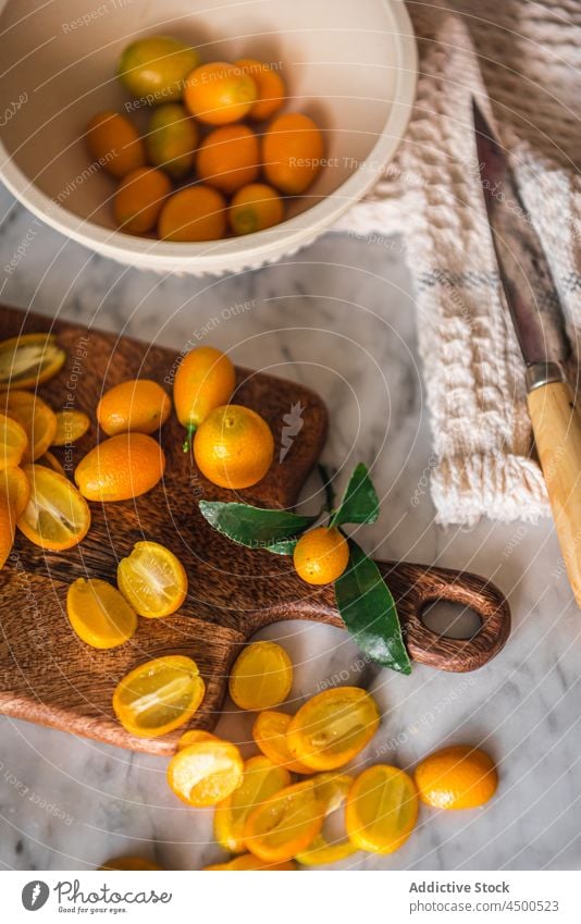 Haufen Kumquats auf Schneidebrett Frucht organisch natürlich gesunde Ernährung Zitrusfrüchte geschnitten Vitamin Küche frisch reif hölzern Gesundheit Murmel