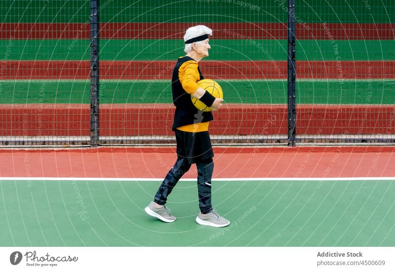 Ältere Frau mit Basketball auf dem Spielplatz Senior Ball spielen Sportpark Hobby Gesunder Lebensstil Beteiligung Training reif Aktivität Sportkleidung Reifen