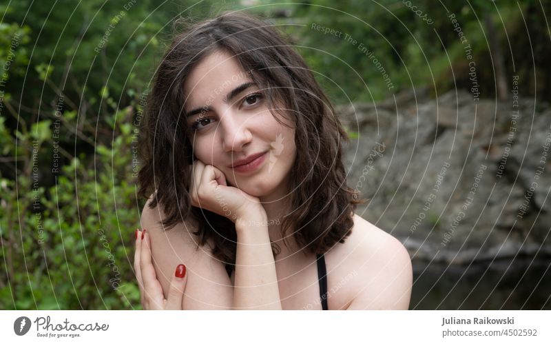 Dunkelhaarige Frau in der Natur - Portrait Frühling draußen sympathisch nett freundlich Lächeln Haarsträhne nachdenklich ästhetisch braune Augen Locken