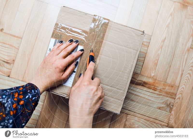 Frau beim Öffnen des Pakets einer Online-Bestellung. Auspacken des Kartons mit den bestellten Artikeln Verpackung Kollo vorbereitend Versand Spedition oben