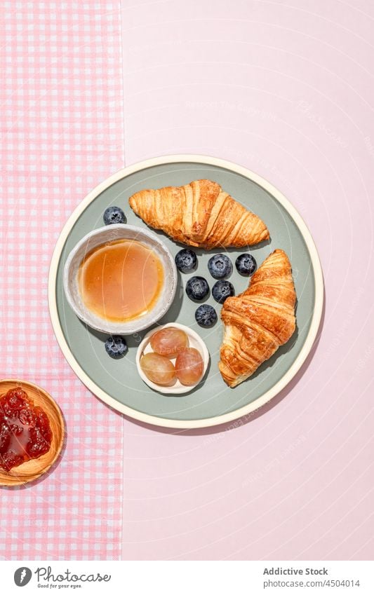 Teller mit leckeren Croissants mit Blaubeeren und Marmelade auf dem Tisch Frühstück frisch dienen geschmackvoll Lebensmittel Dessert süß Gebäck Beeren gebacken