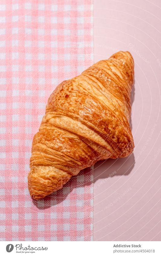 Frisch gebackenes Croissant auf dem rosa Tisch lecker geschmackvoll Dessert Tischwäsche süß Lebensmittel frisch Bäckerei Produkt Kalorie Tageslicht Ernährung