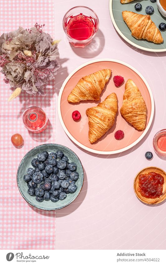 Teller mit leckeren Croissants, serviert mit Marmelade und Beeren, stehen auf dem Tisch Dessert süß Frühstück Lebensmittel Gebäck Morgen frisch geschmackvoll