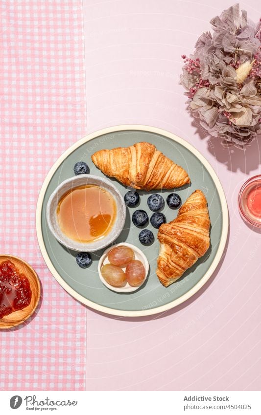 Teller mit leckeren Croissants mit Blaubeeren und Marmelade auf dem Tisch Frühstück frisch dienen geschmackvoll Lebensmittel Dessert süß Gebäck Beeren gebacken