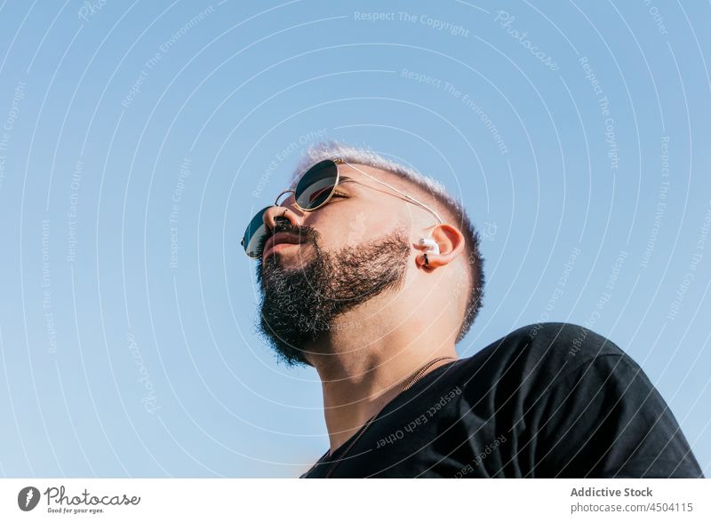 Bärtiger Mann mit Sonnenbrille gegen wolkenlosen blauen Himmel Windstille besinnlich nachdenklich Individualität trendy Vorschein Persönlichkeit Blauer Himmel